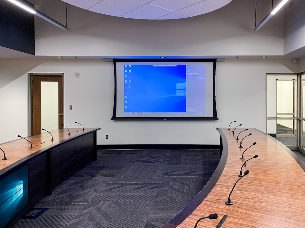 Final table installation with AV integration facing multiple screens
